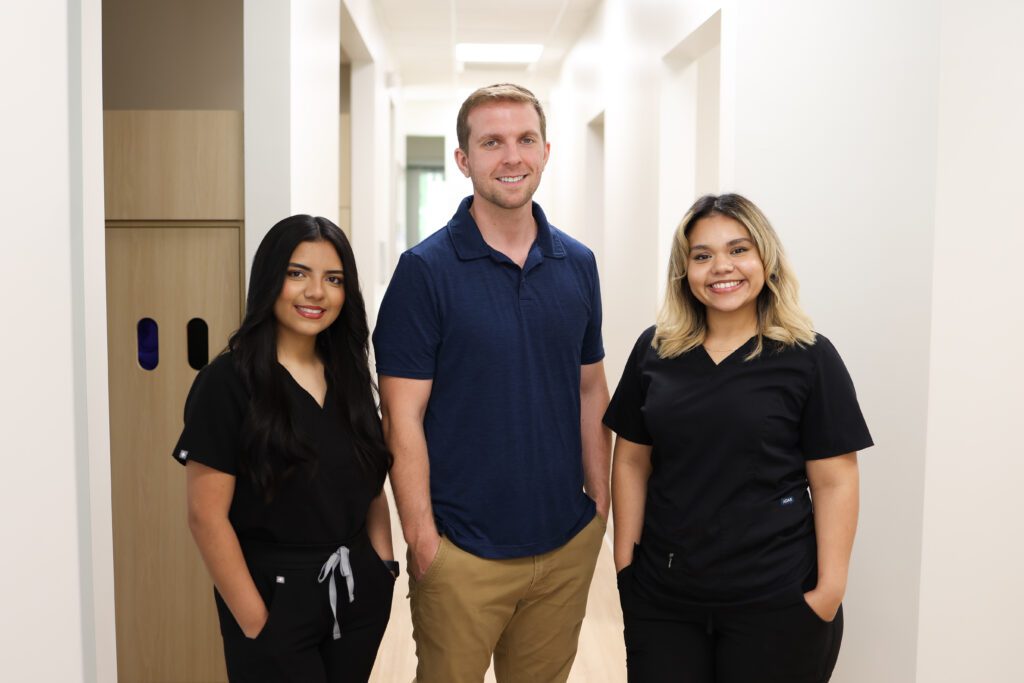 Professional dental team standing together in a modern clinic hallway, representing trusted family dental care in Knightdale NC – dentist knightdale nc